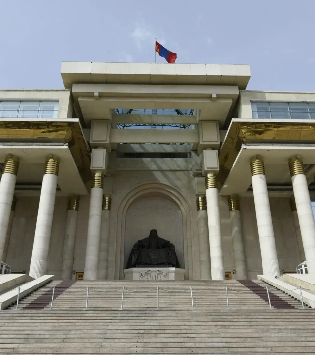 pexels-photo-19374508-19374508-3 Front view of the historic Government Palace in Ulaanbaatar with Genghis Khan statue and columns.