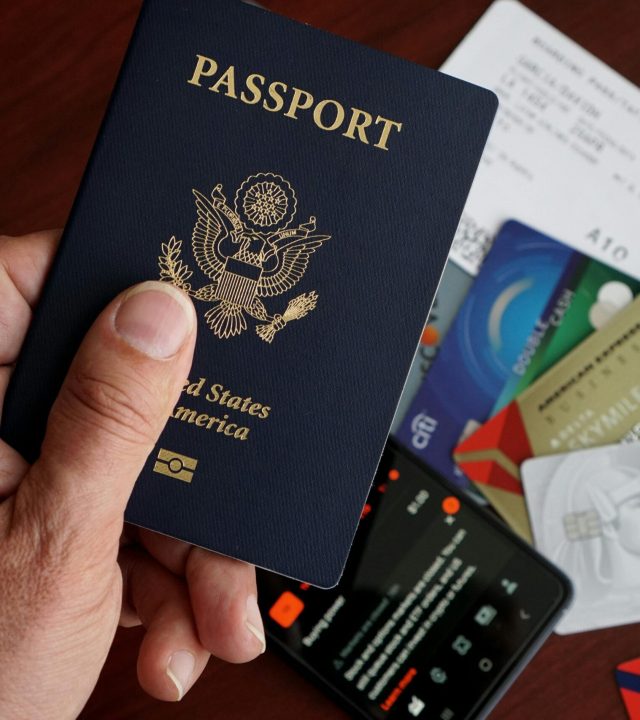 pexels-photo-32642491-32642491 US Passport over a Smartphone Credit Cards Flight Ticket